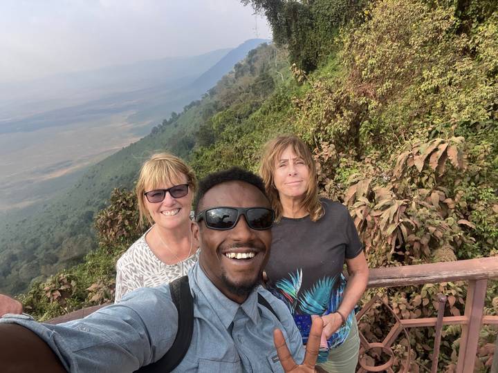 Un selfie de groupe avec une végétation luxuriante et une vue sur la vallée.