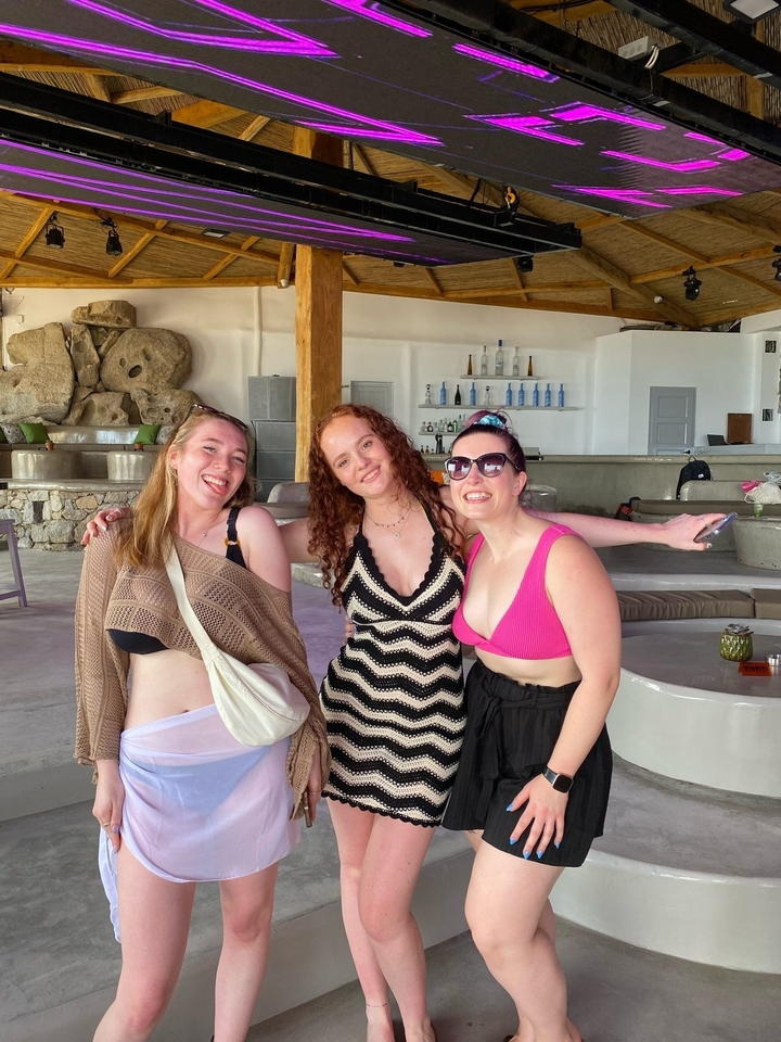 Trois femmes posant à l'intérieur avec des sourires.