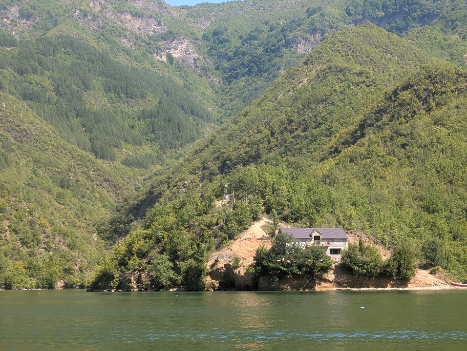 Maison sur une colline entourée de forêts verdoyantes luxuriantes.