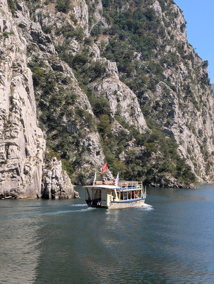 Bateau touristique naviguant à travers une gorge rocheuse.