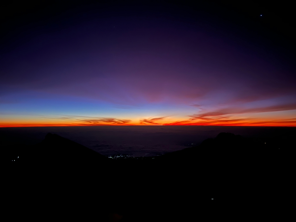Coucher de soleil avec un ciel vibrant au-dessus des montagnes.