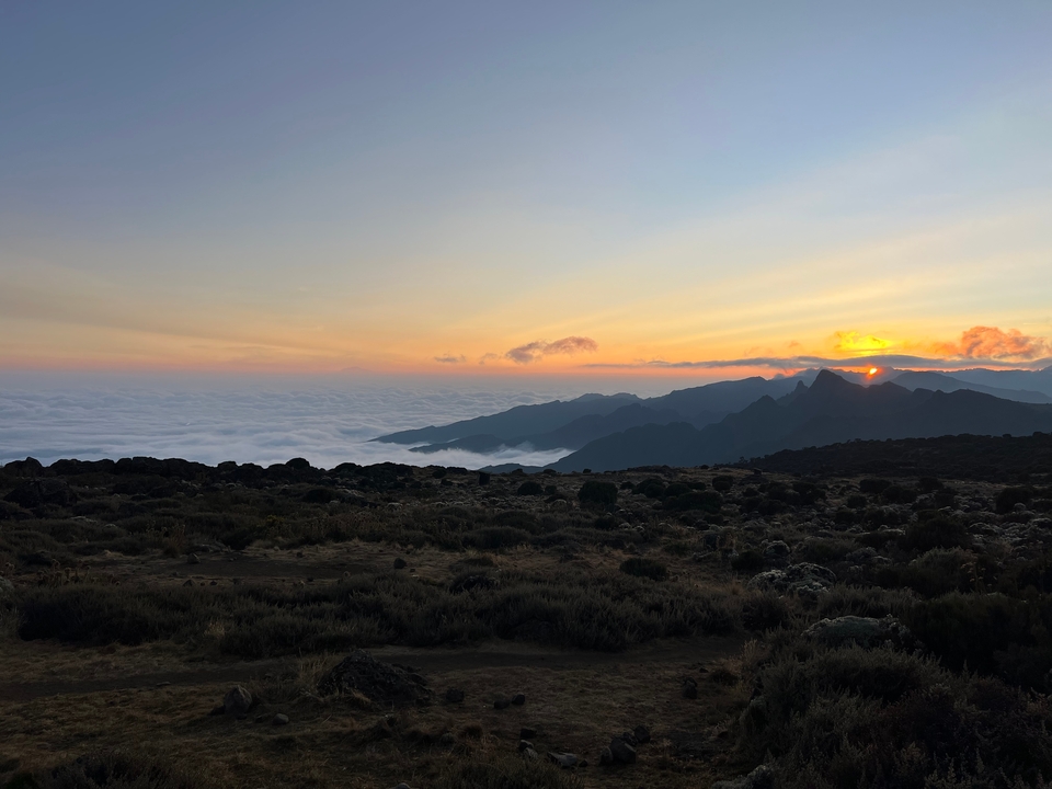 Lever de soleil sur des montagnes et une mer de nuages.