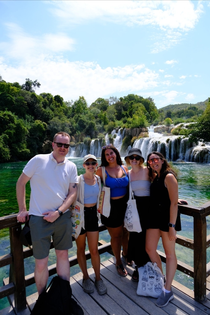 Group of people posing in front of waterfalls.