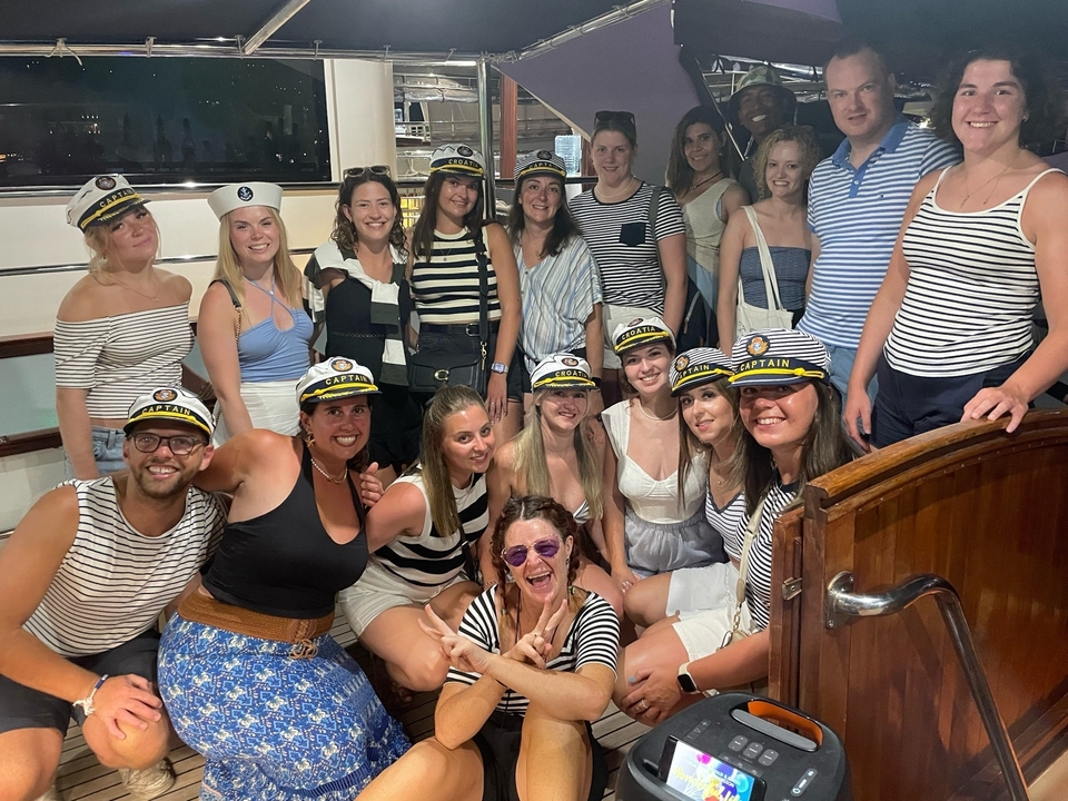 Groupe de personnes sur un bateau portant des casquettes de capitaine.