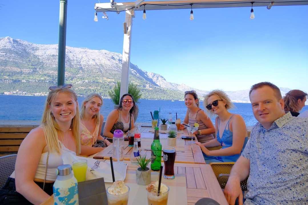 Group of people dining with a scenic water view.