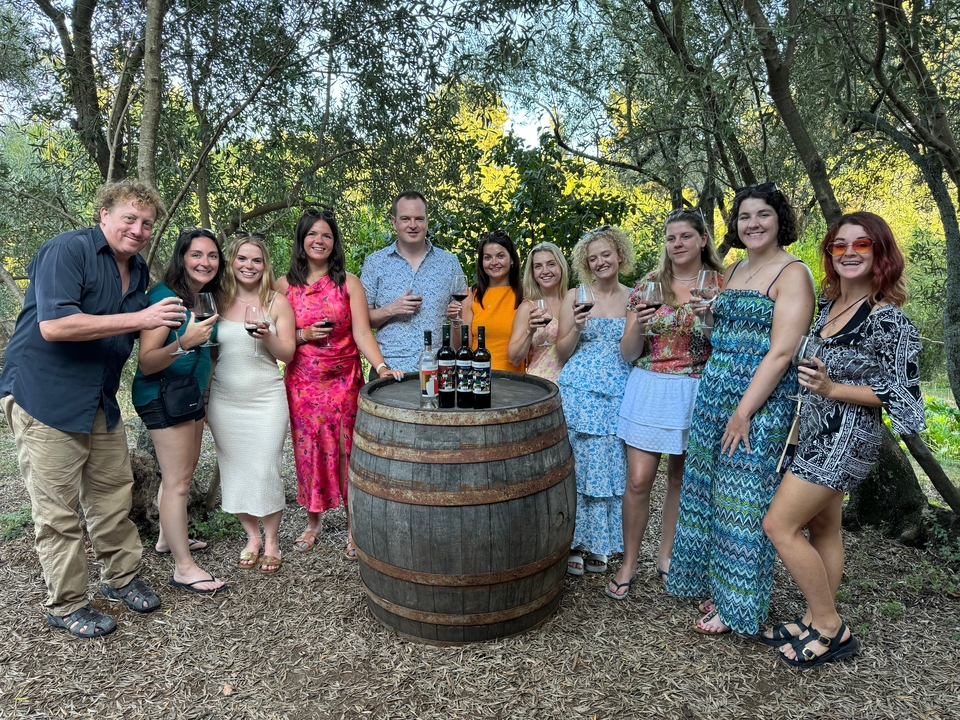 Group of people enjoying drinks in a forest setting.