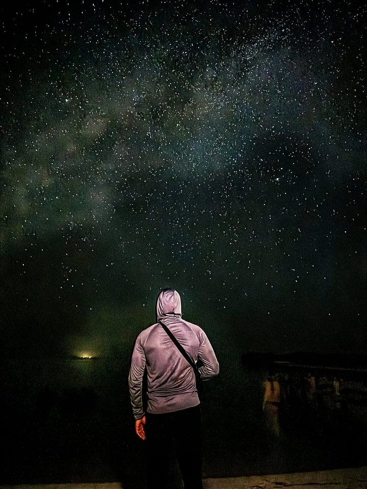 Personne qui observe les étoiles sous un ciel nocturne dégagé.