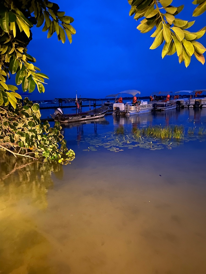Des bateaux sur un lac la nuit avec des reflets.