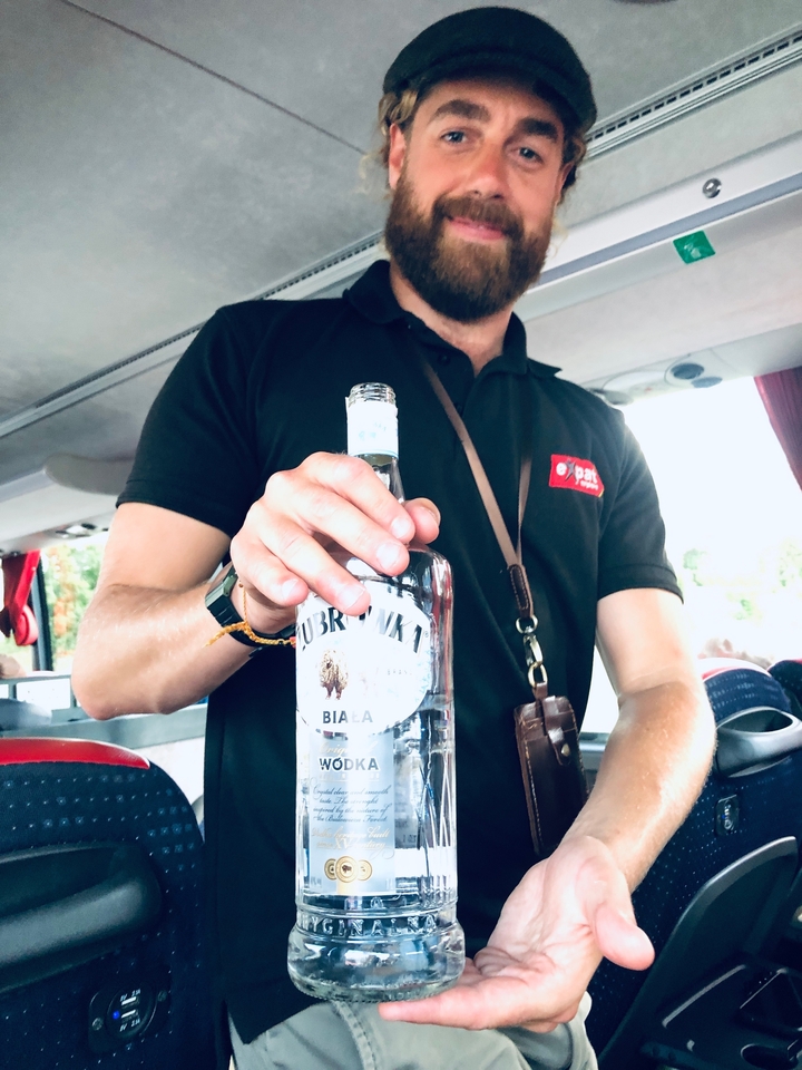 Personne tenant une bouteille de vodka dans un véhicule.