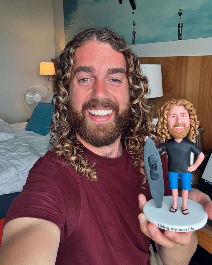 Une personne souriante à l'intérieur avec une petite figurine.