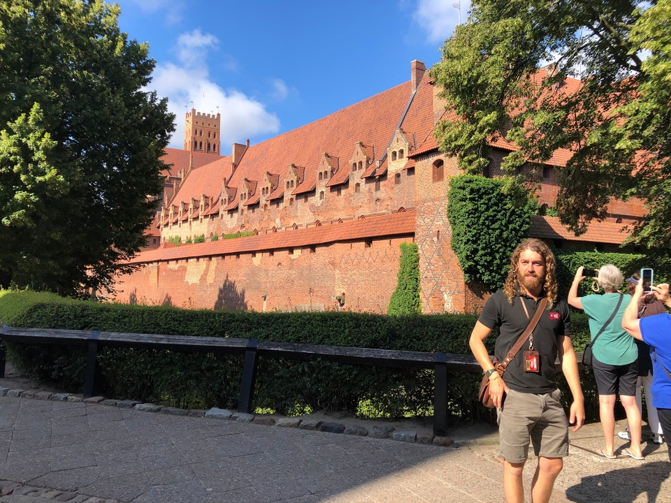 Guide touristique devant le château de Malbork.