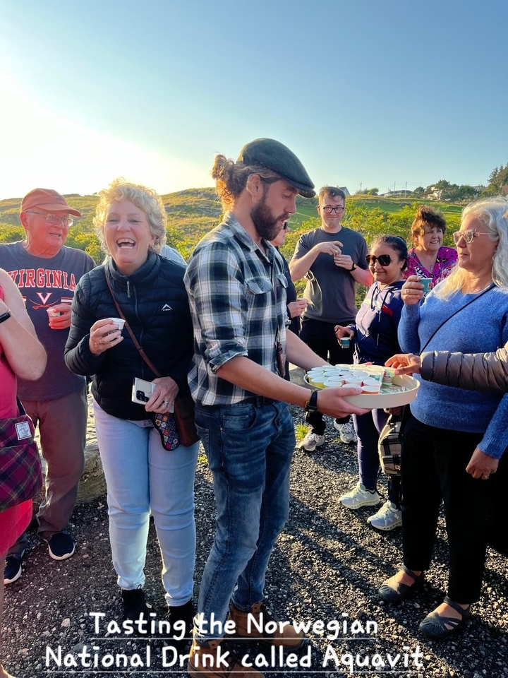 Un groupe de personnes profitant de boissons en plein air avec une vue panoramique en arrière-plan.