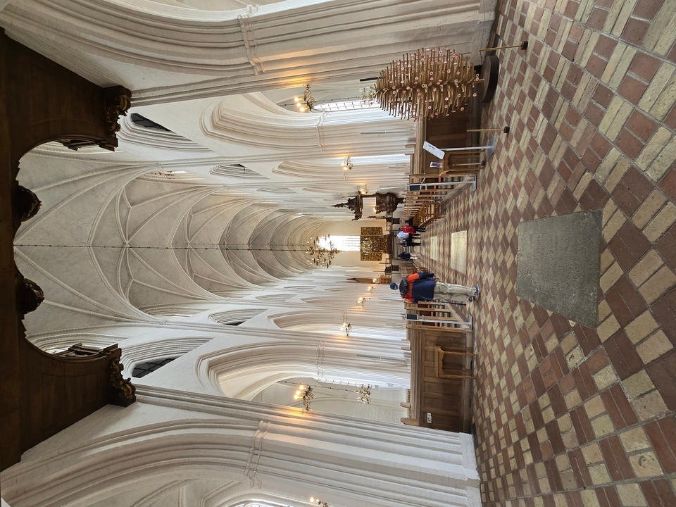 Intérieur d'une église avec des plafonds voûtés et des lustres.