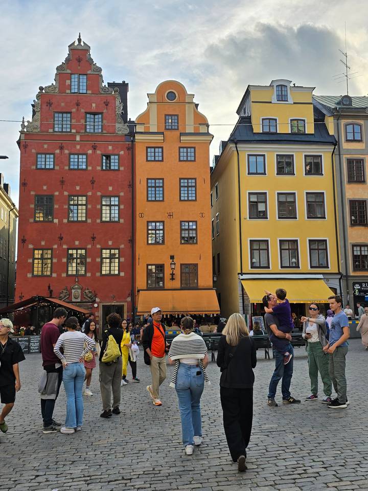 Bâtiments colorés avec des gens qui se rassemblent devant.