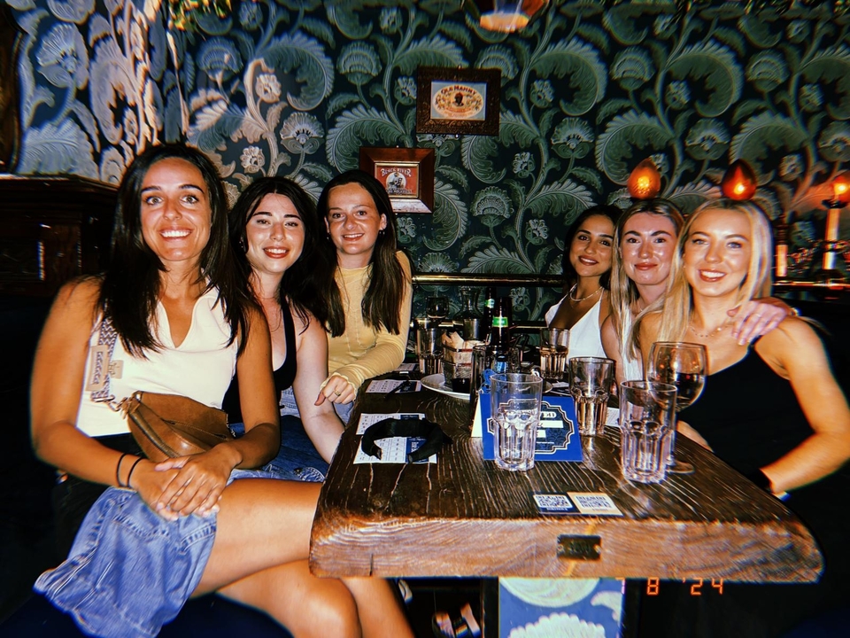 Group of women seated at a restaurant or bar table.