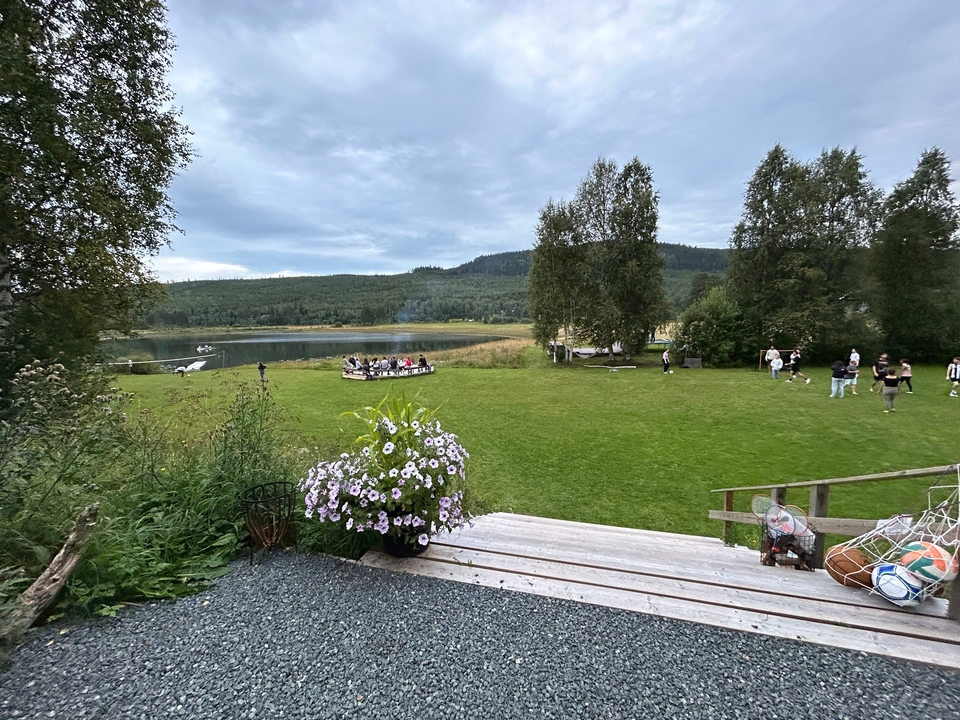 A scenic viewpoint with people gathered near a lake.