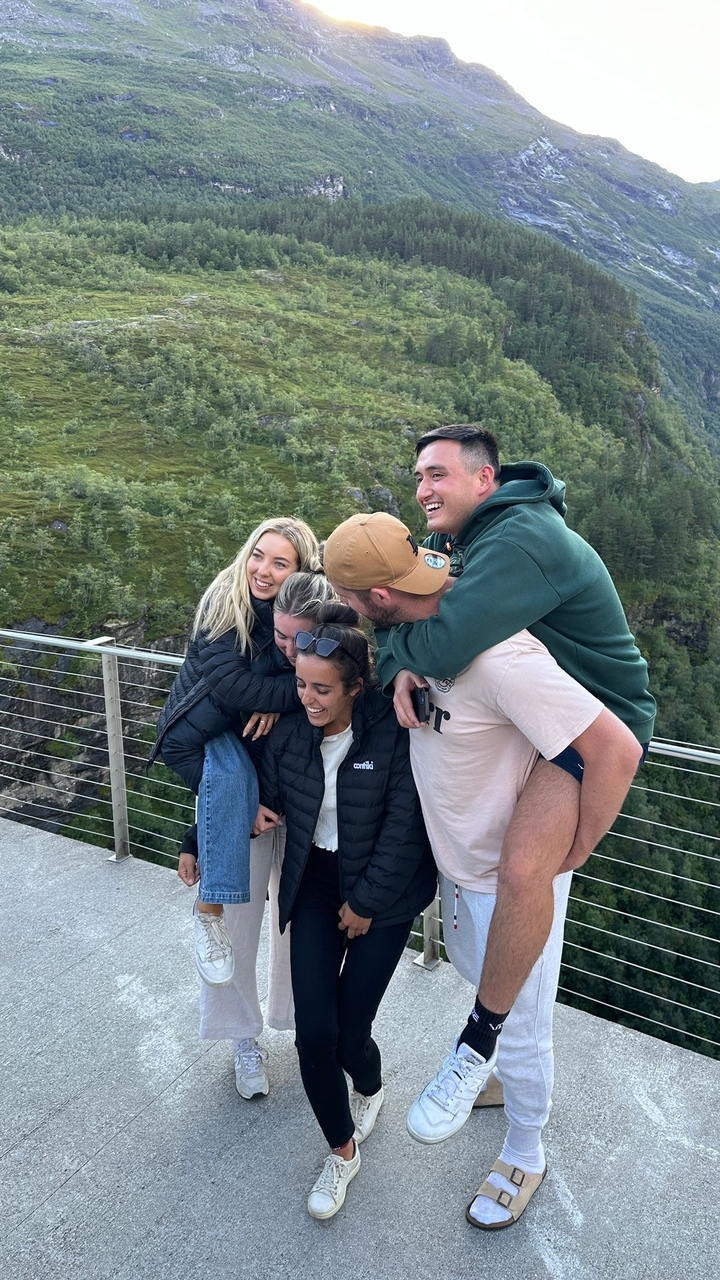 Groupe d'amis posant joyeusement dans un lieu extérieur pittoresque.