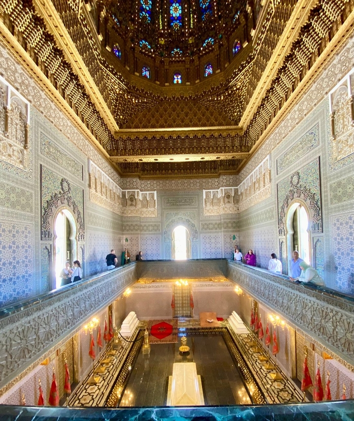 Des personnes admirant l'intérieur magnifiquement décoré d'un palais.