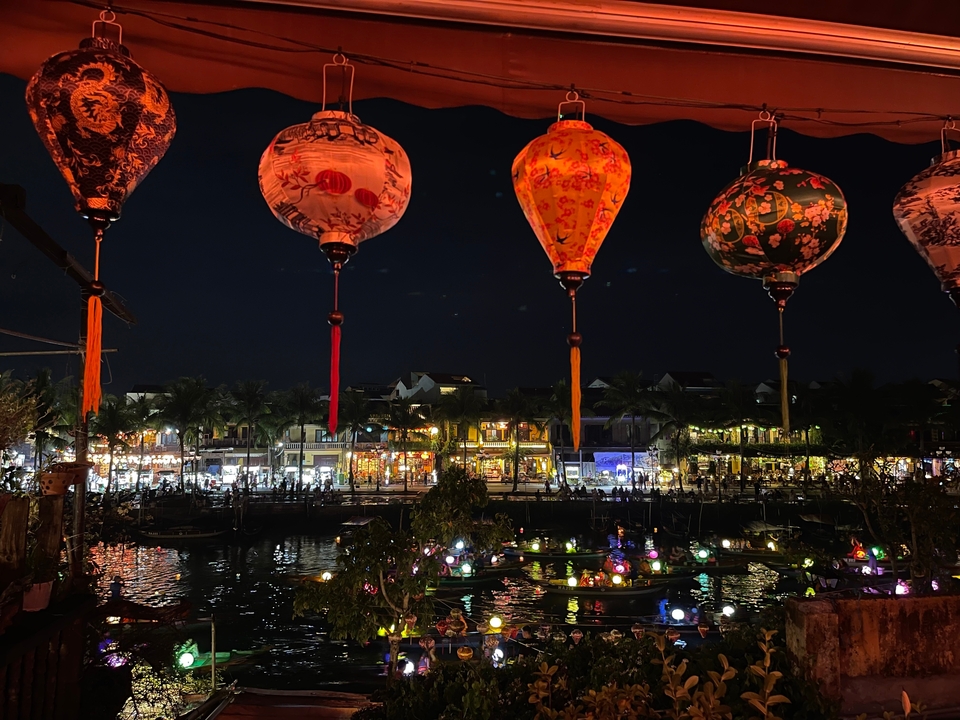 Lanternes colorées la nuit au-dessus d'un front de mer animé.
