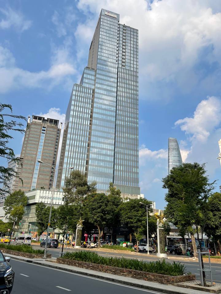 Gratte-ciel modernes contre un ciel bleu avec quelques nuages.