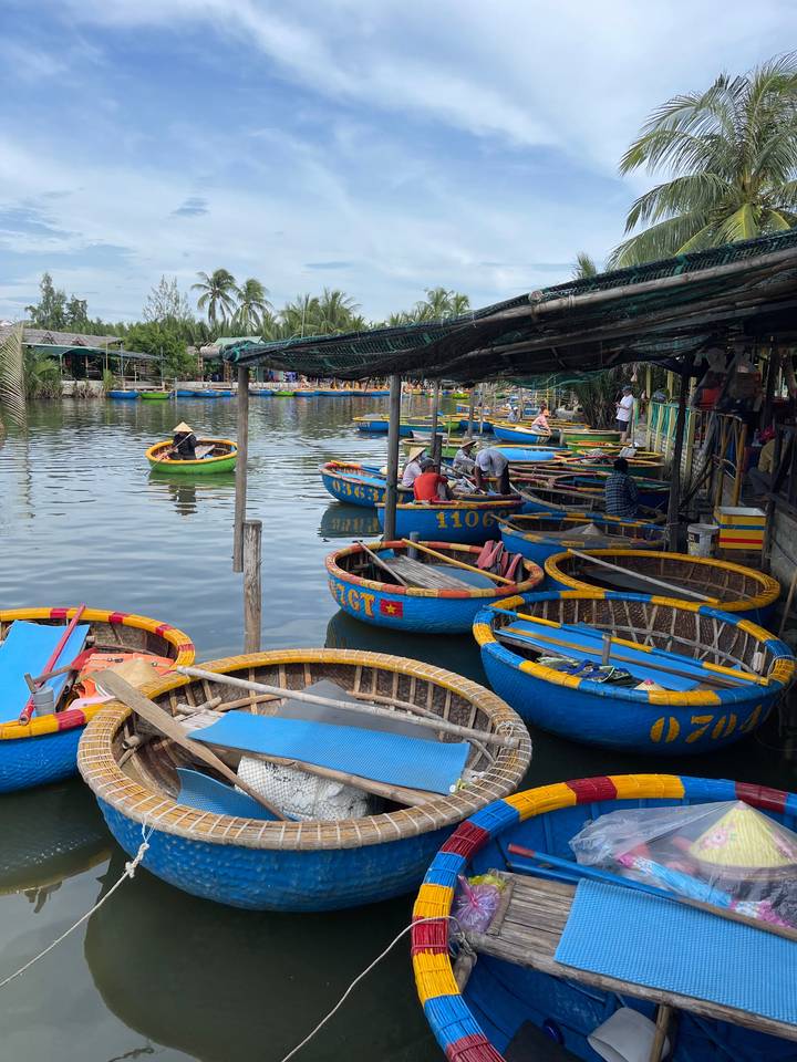 Bateaux ronds amarrés le long d'une rivière dans un cadre de marché.