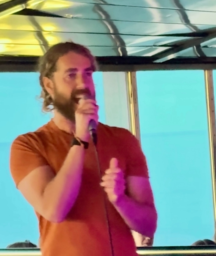 Image floue d'une personne chantant dans un microphone dans une pièce éclairée.