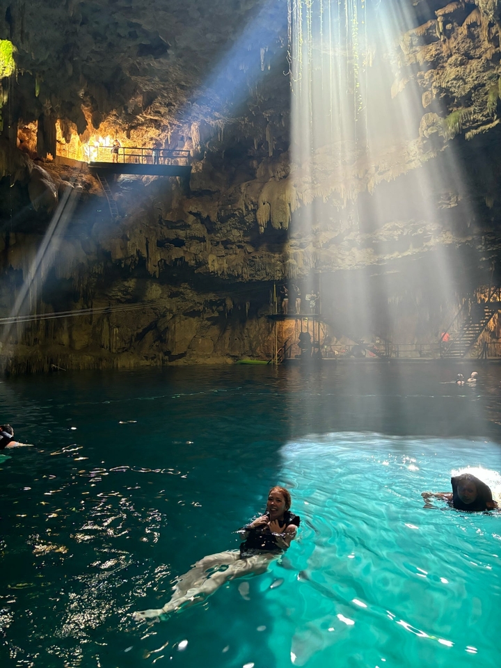 Une grotte intérieure avec un bassin d'eau et la lumière naturelle qui filtre à l'intérieur.
