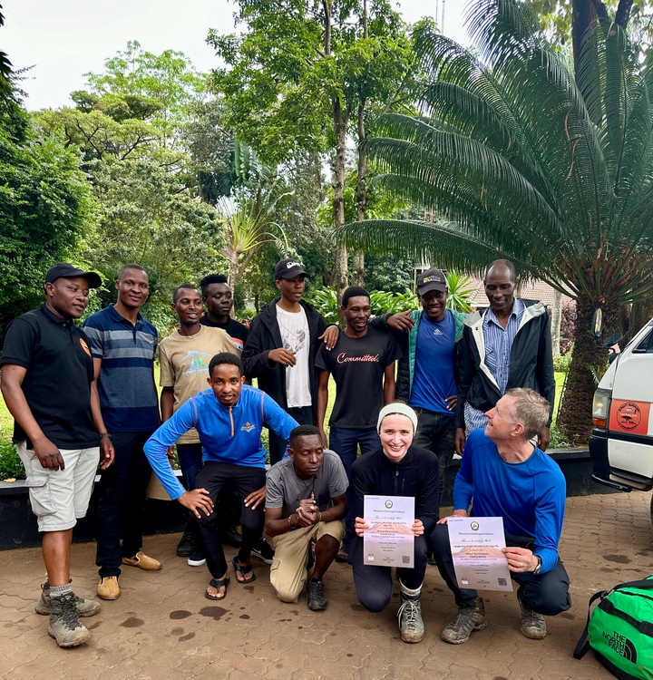 Groupe de personnes posant ensemble à l'extérieur avec de la verdure tropicale.