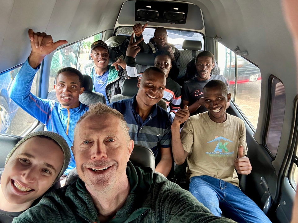 Groupe de personnes à l'intérieur d'un véhicule, souriant et faisant le geste du pouce levé.