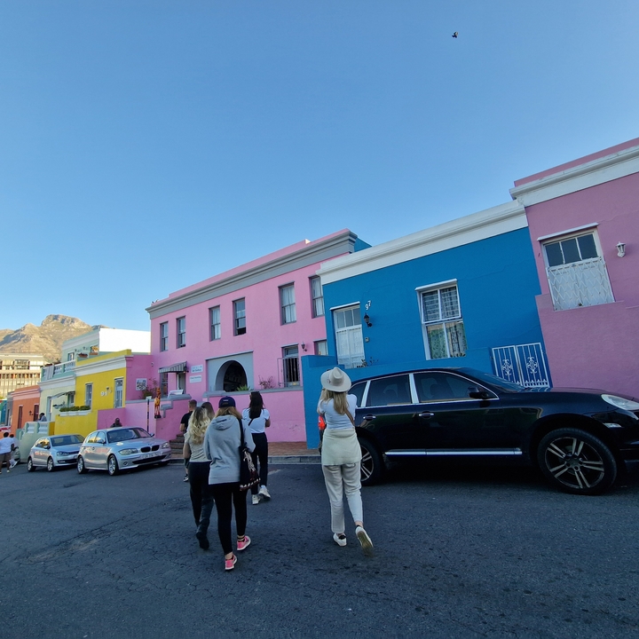 Maisons colorées dans un quartier animé avec des montagnes.