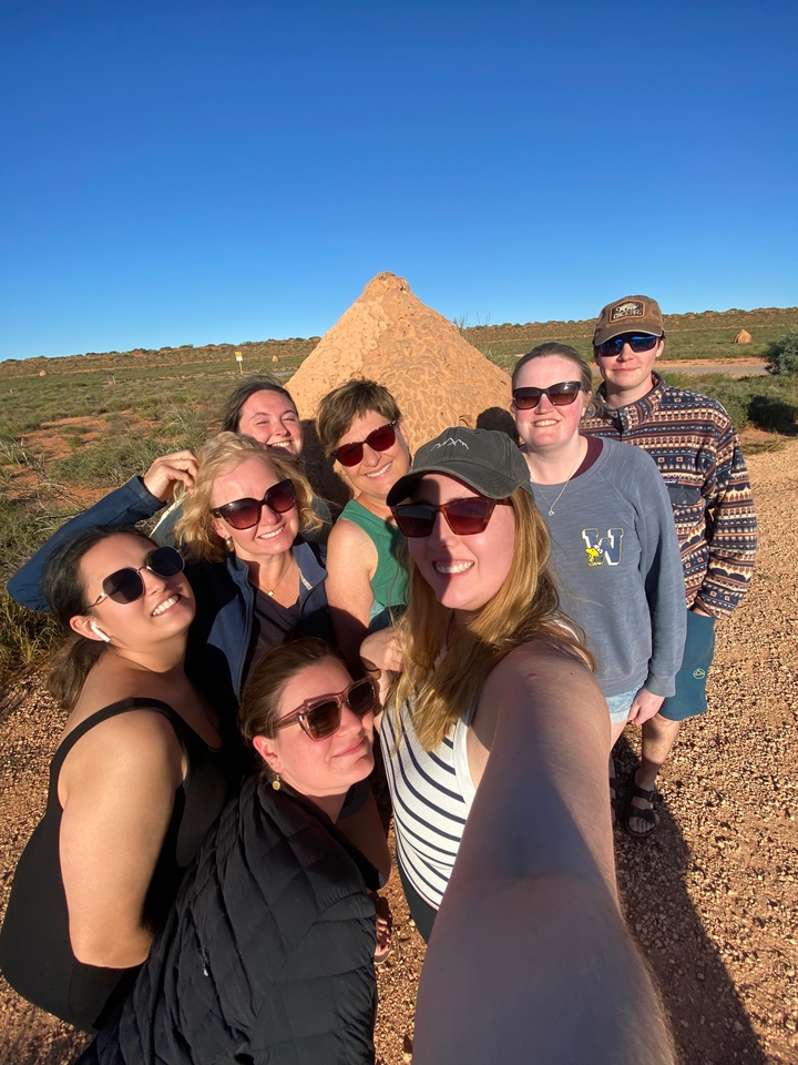 Selfie d'un groupe d'amis à l'extérieur avec une formation rocheuse.