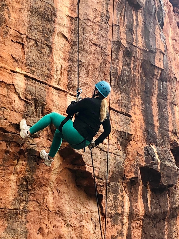Personne qui fait de l'escalade sur une falaise escarpée.