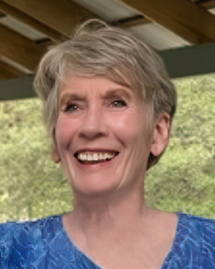 Femme souriante aux cheveux courts regardant l'appareil photo à l'extérieur.