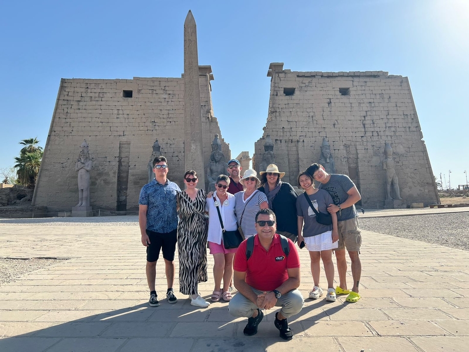 Groupe de touristes posant devant un temple historique.