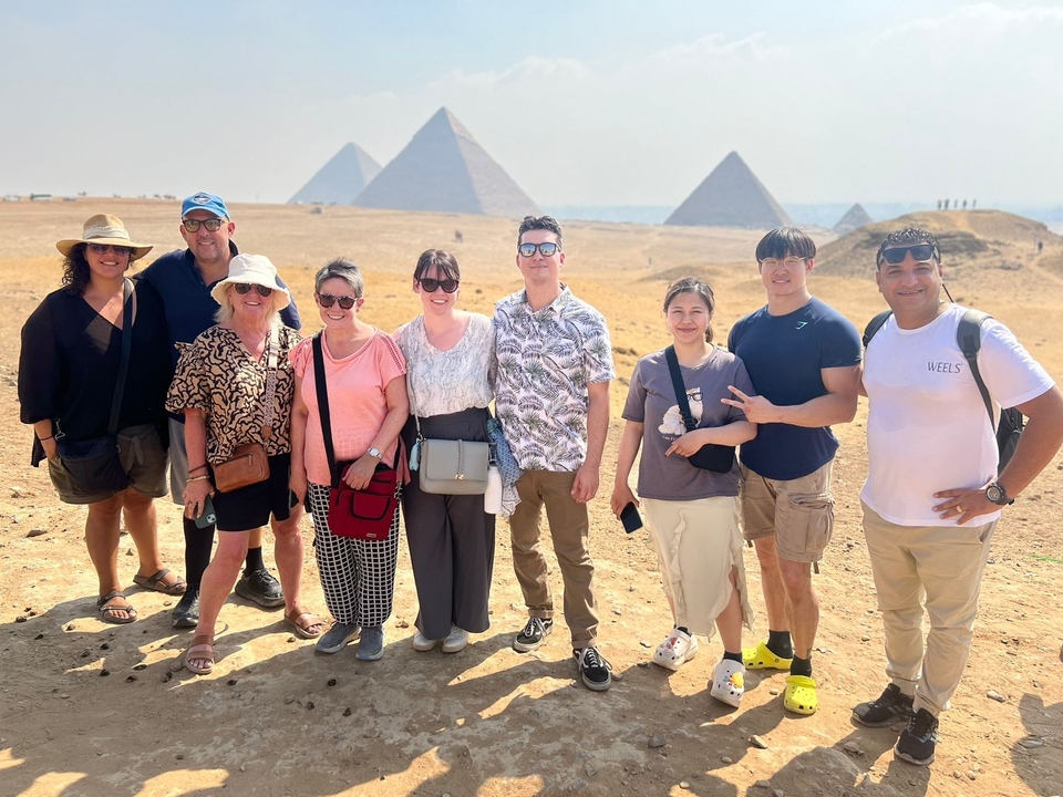 Touristes posant avec les pyramides de Gizeh.