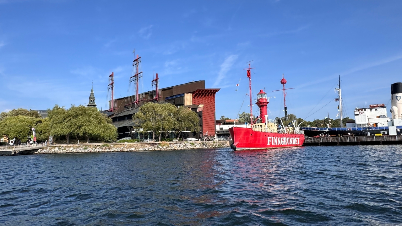 Un port avec un navire rouge et des bâtiments modernes.