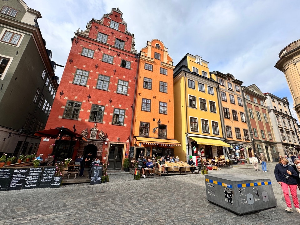 Place animée avec des bâtiments historiques colorés.