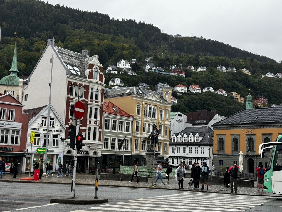Une scène de ville avec de vieux bâtiments colorés et des collines en arrière-plan.