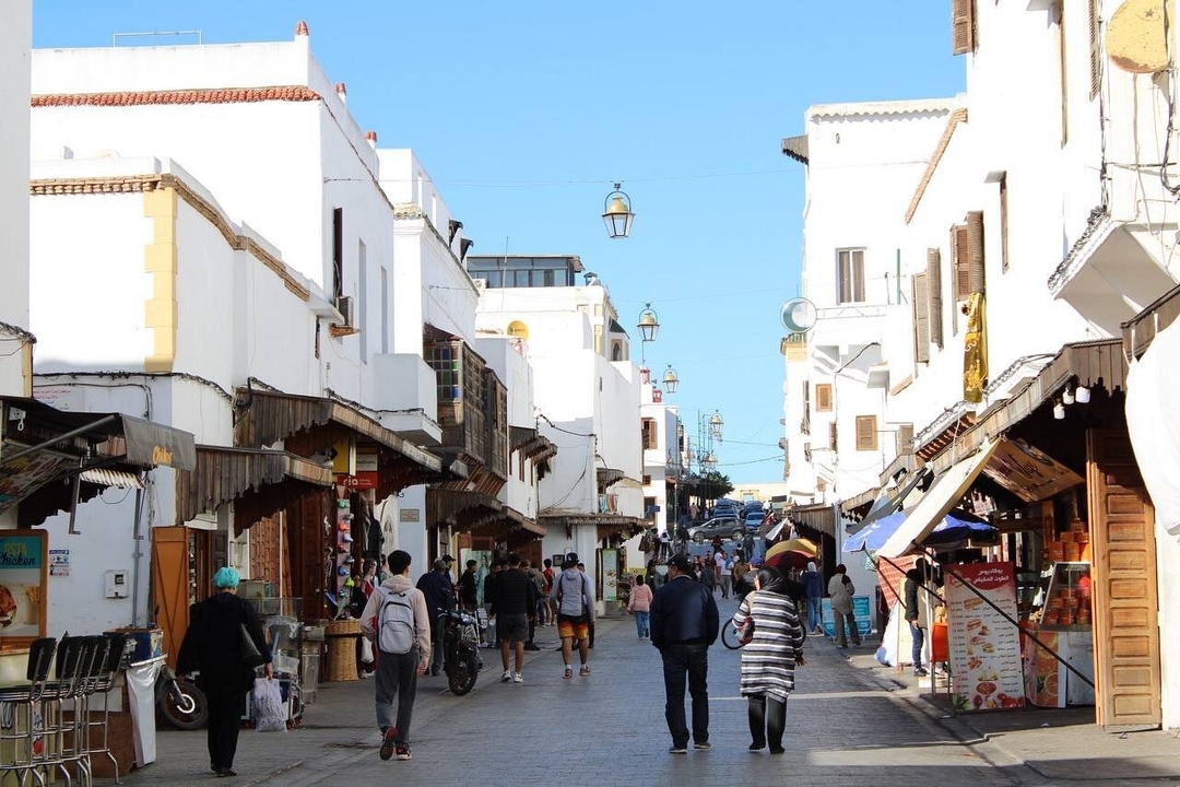 Rue animée à Rabat avec des gens et des magasins.