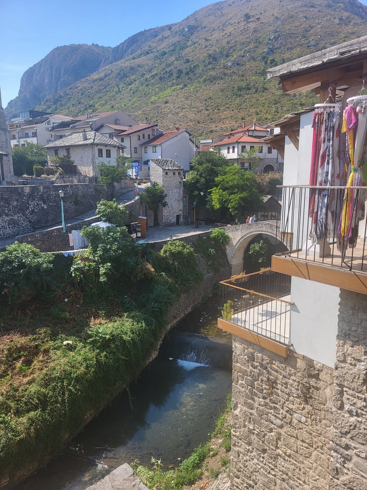 Vue panoramique d'un pont en pierre et de bâtiments au bord d'une rivière.