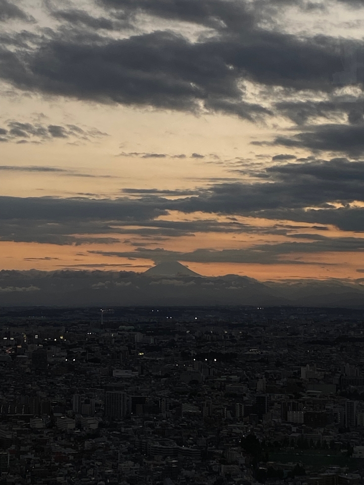 Silhouette de montagne au coucher du soleil avec les lumières de la ville.