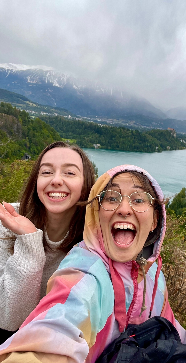 Deux personnes souriantes avec une vue sur un lac en arrière-plan.