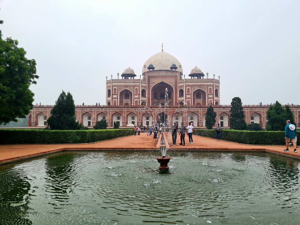 Monument historique avec un jardin symétrique et une fontaine.