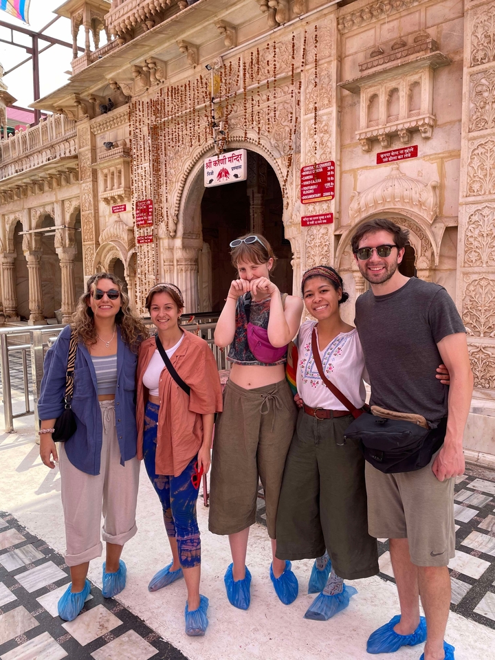 Groupe d'amis posant devant un temple aux sculptures complexes.