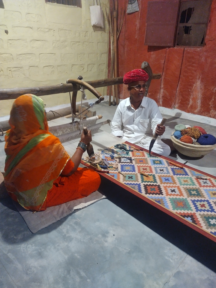 Deux personnes travaillant sur un métier à tisser traditionnel.
