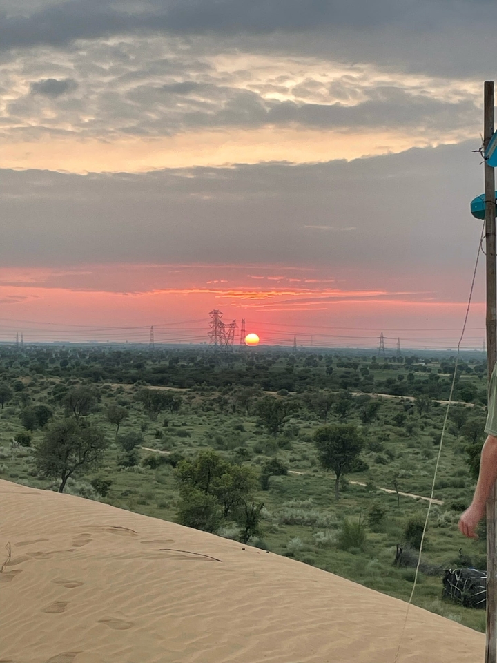 Vue du coucher de soleil sur un paysage avec des lignes électriques.