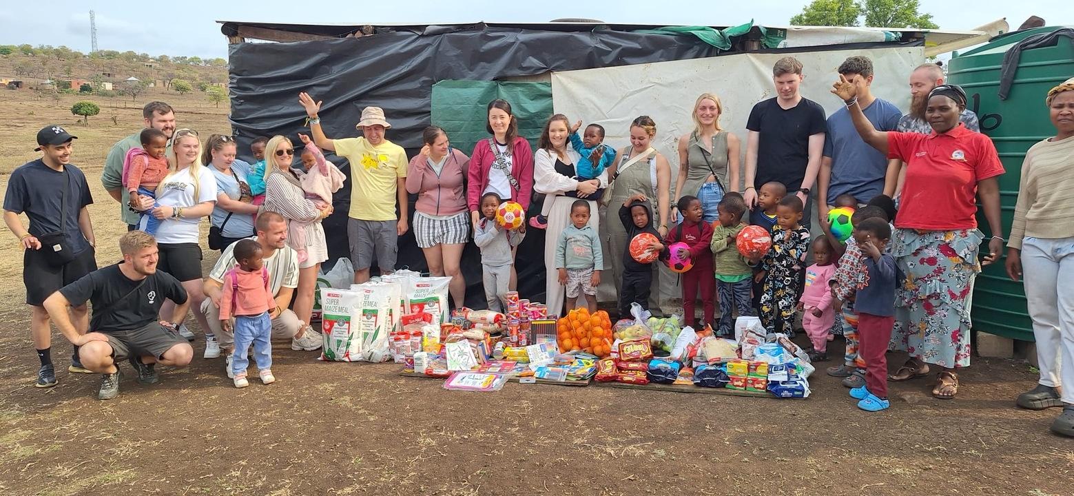 Groupe de personnes avec des enfants et des provisions à l'extérieur.