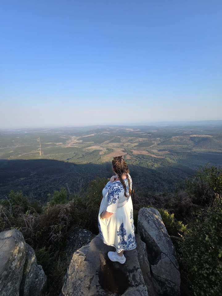 Femme admirant un paysage pittoresque depuis un point de vue élevé.