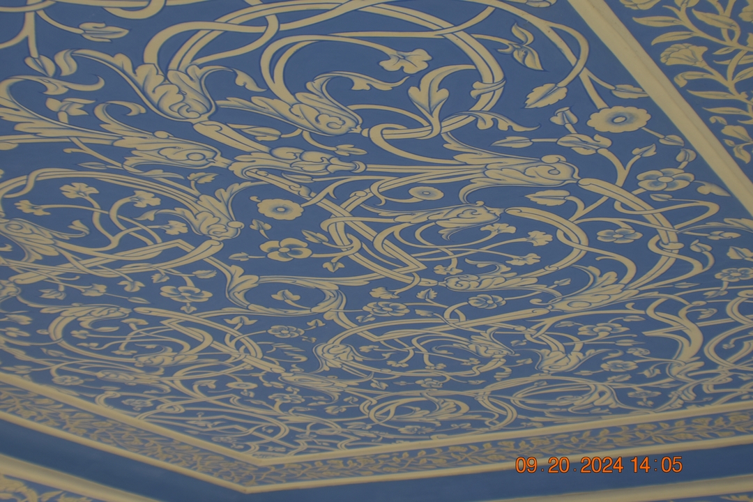 Motif détaillé sur un plafond bleu.