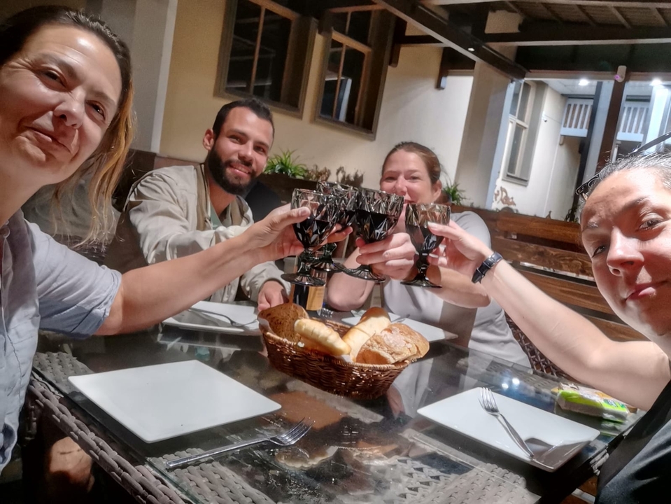 Cuatro personas brindando con bebidas en una mesa de comedor.